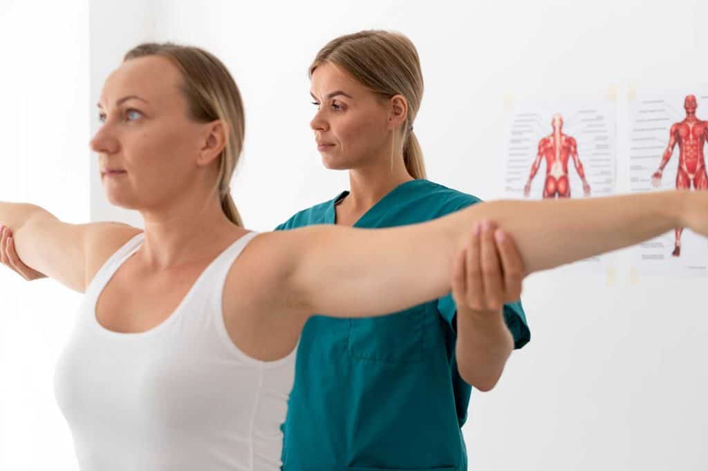 Doctor examining patient's shoulder range of motion.