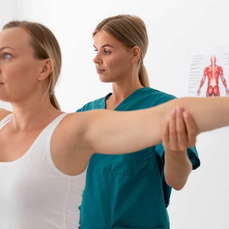 Doctor examining patient's shoulder range of motion.