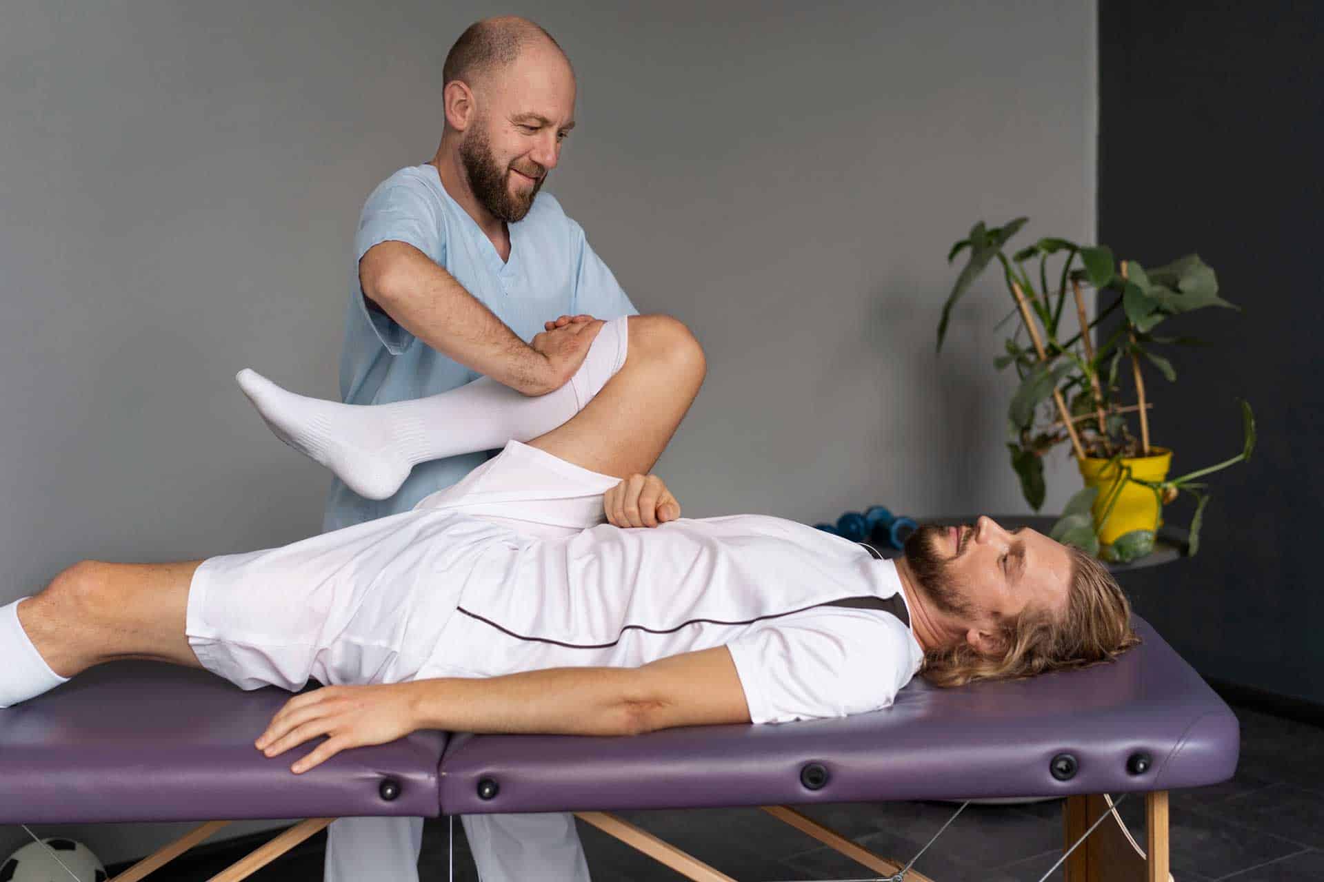 Doctor helping an athlete with his knee rehabilitation and stretching.