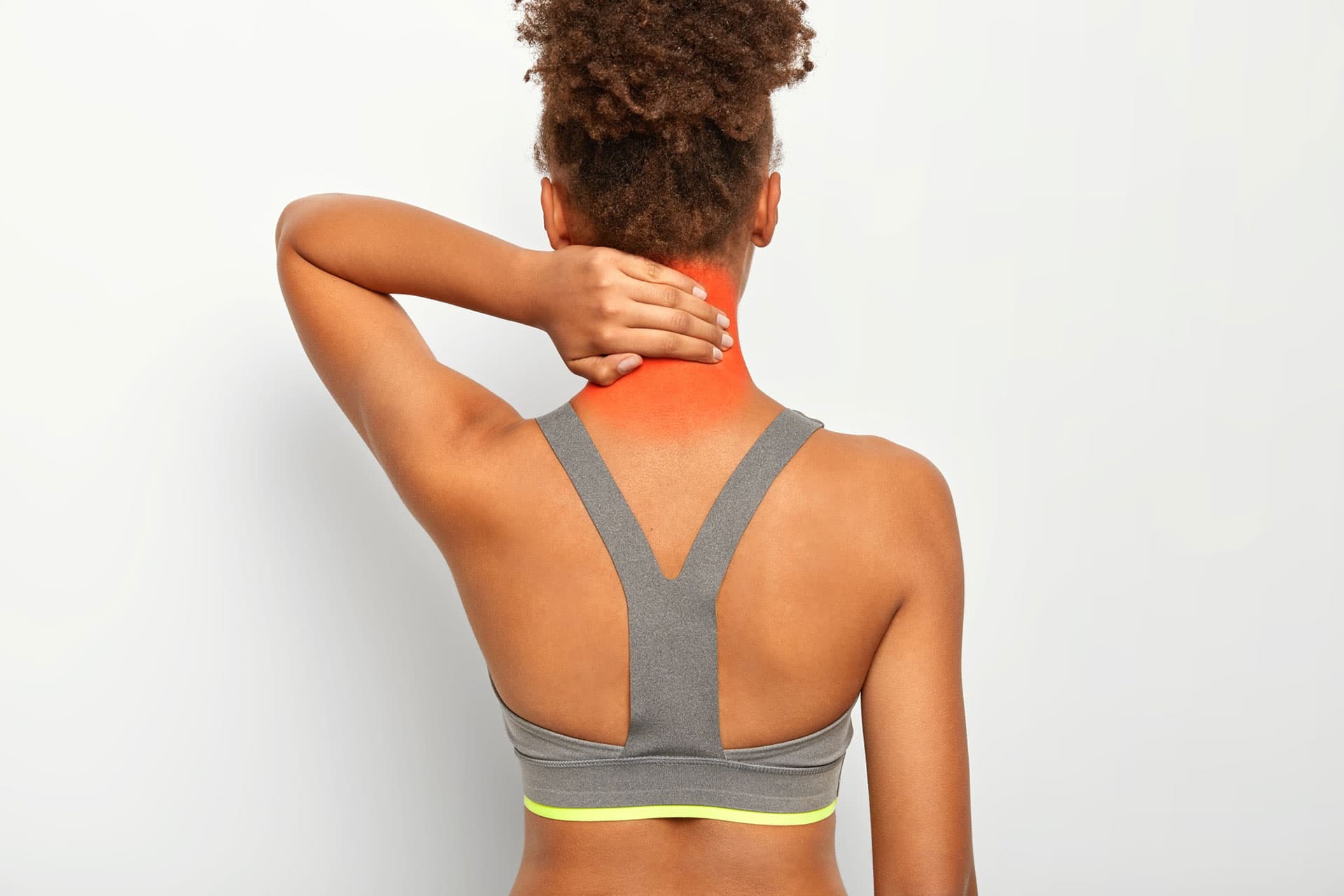 Woman experiencing neck pain holding her neck, emphasizing chiropractic treatment for pain management.