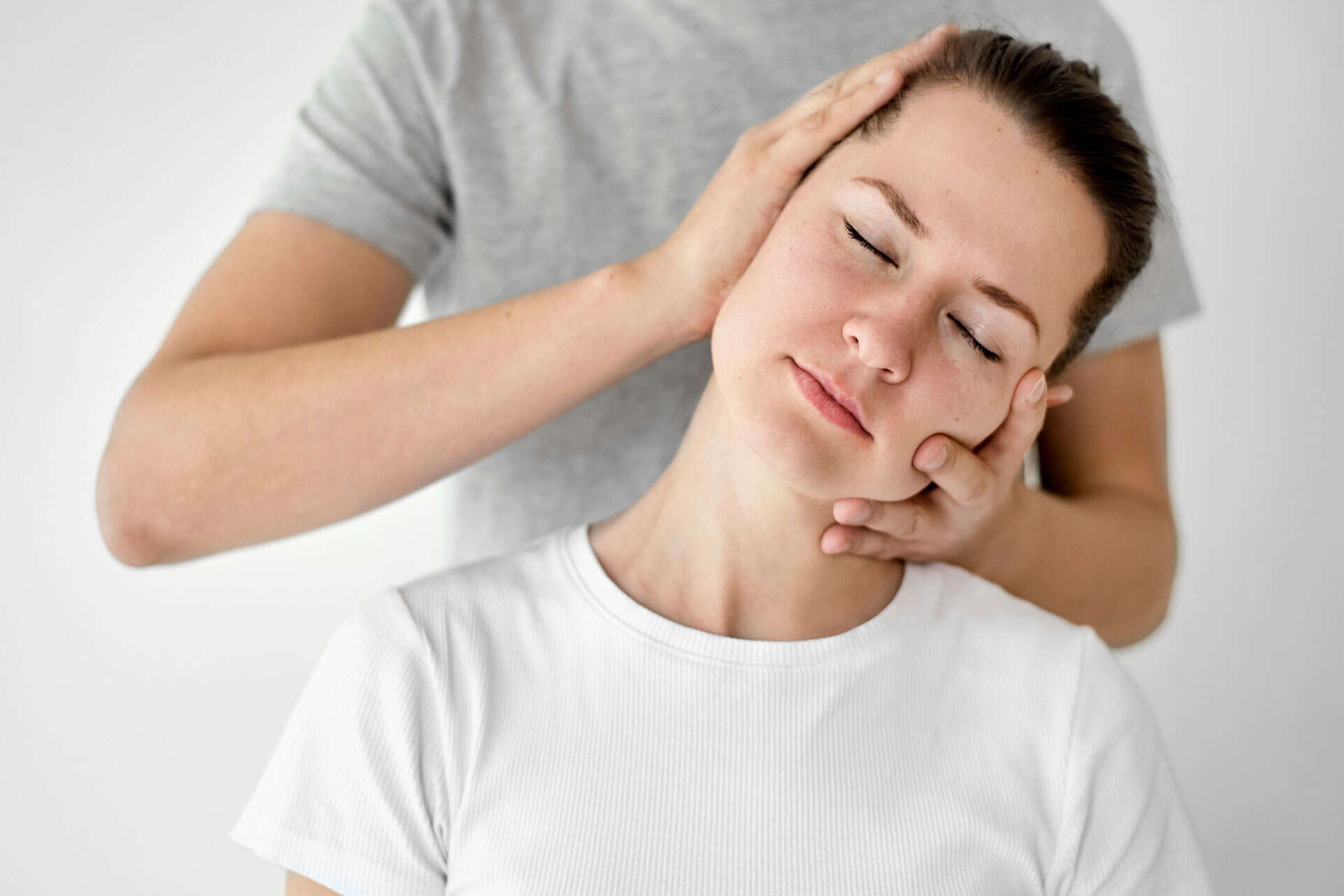 Young woman receiving professional neck chiropractic adjustment.