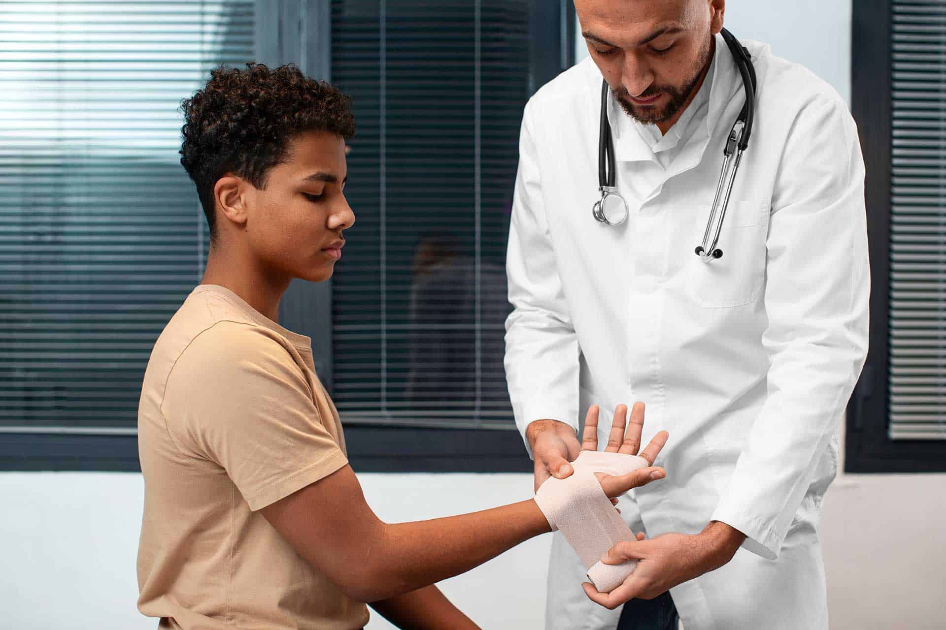 Clinician applying a supportive bandage on a patient’s wrist during consultation.