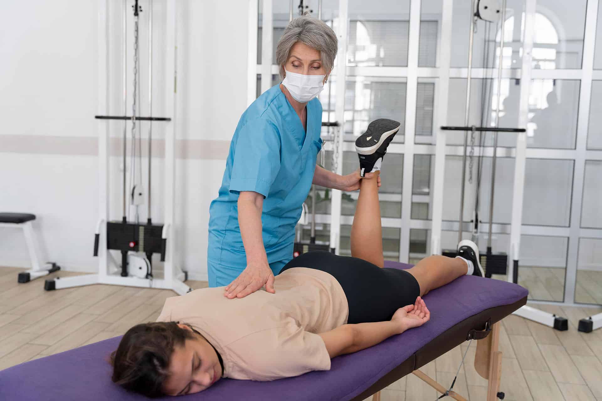 Chiropractor performing spinal adjustment on female patient in a modern clinic.
