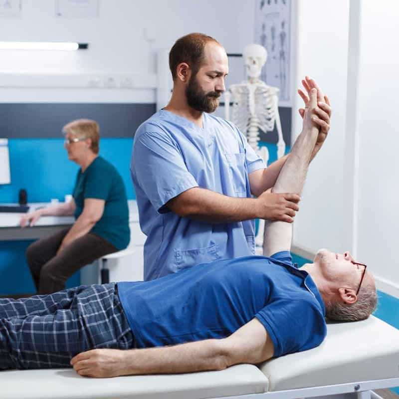 Physical therapist providing manual therapy and soft tissue treatment to senior patient
