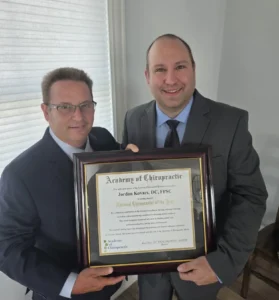 Dr. Jordan Kovacs receiving the 2026 National Chiropractor of the Year award from the Academy of Chiropractic.
